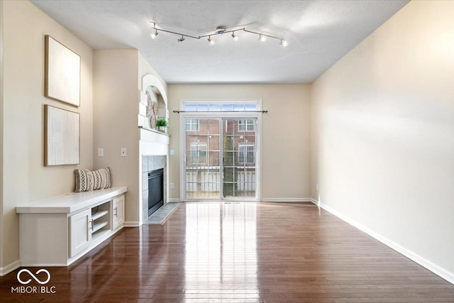8256 Jo Ellen Dr, Fishers, IN 46038 - unfurnished living room featuring dark wood-style floors and a tile fireplace