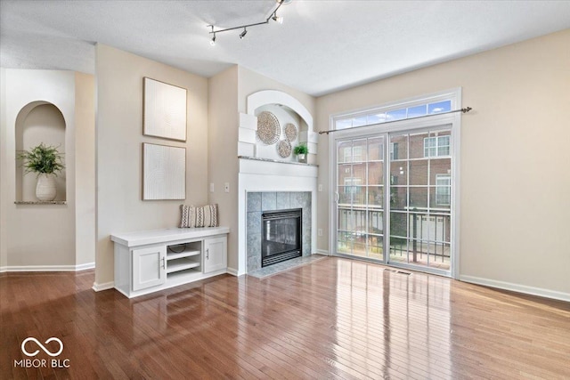 8256 Jo Ellen Dr, Fishers, IN 46038 - unfurnished living room with hardwood / wood-style floors and a tiled fireplace