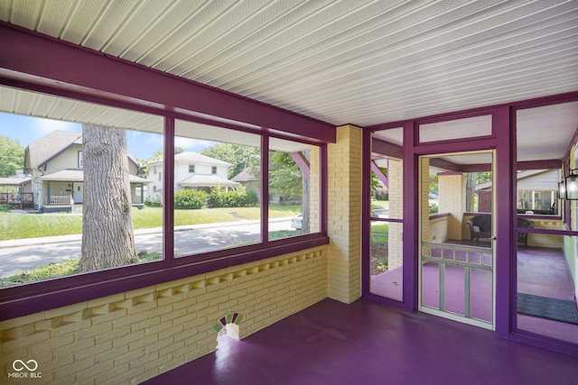 5050 Carrollton Ave, Indianapolis, IN 46205 - unfurnished sunroom with brick wall and concrete flooring