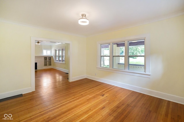 5050 Carrollton Ave, Indianapolis, IN 46205 - spare room with light wood-type flooring, ornamental molding, a brick fireplace, and a ceiling fan