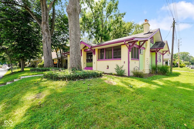 5050 Carrollton Ave, Indianapolis, IN 46205 - view of front of house with brick siding, a chimney, and a front lawn