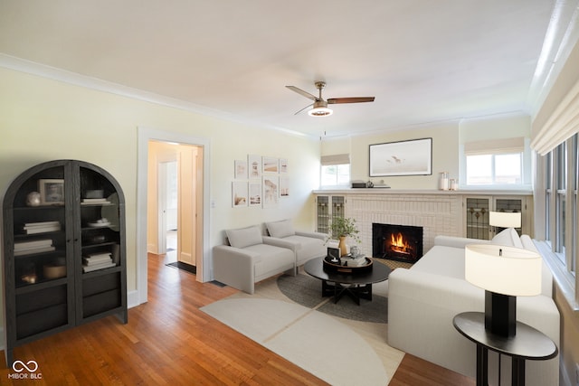 5050 Carrollton Ave, Indianapolis, IN 46205 - living area with light wood-style floors, a brick fireplace, a ceiling fan, and crown molding