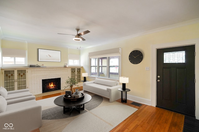 5050 Carrollton Ave, Indianapolis, IN 46205 - living area with crown molding, wood finished floors, ceiling fan, and a brick fireplace