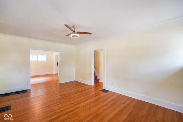 5050 Carrollton Ave, Indianapolis, IN 46205 - empty room featuring a ceiling fan, light wood-style floors, crown molding, and stairway