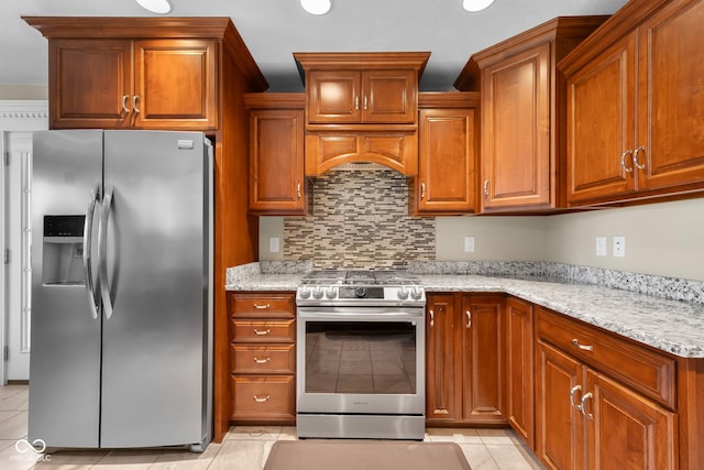 2533 Violet Way, Columbus, IN 47201 - kitchen featuring stainless steel appliances, light tile patterned floors, decorative backsplash, light stone countertops, and brown cabinetry