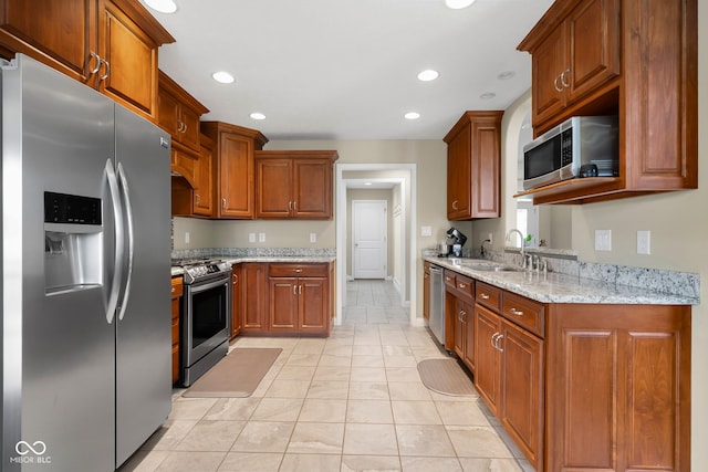 2533 Violet Way, Columbus, IN 47201 - kitchen with appliances with stainless steel finishes, brown cabinets, light stone countertops, recessed lighting, and light tile patterned floors