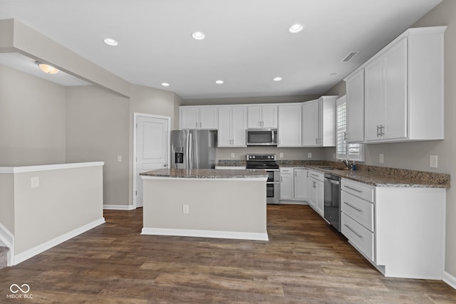 5398 Marigold Dr, Plainfield, IN 46168 - kitchen with appliances with stainless steel finishes, a kitchen island, white cabinets, dark wood-type flooring, and recessed lighting