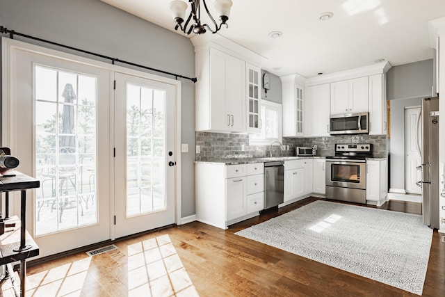 12861 Clifford Cir, Carmel, IN 46032 - kitchen featuring appliances with stainless steel finishes, healthy amount of natural light, tasteful backsplash, and white cabinetry
