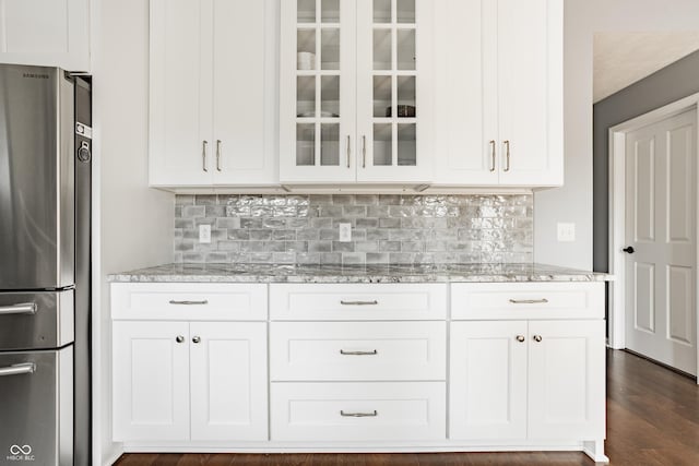 12861 Clifford Cir, Carmel, IN 46032 - kitchen with freestanding refrigerator, glass insert cabinets, light stone counters, white cabinets, and tasteful backsplash