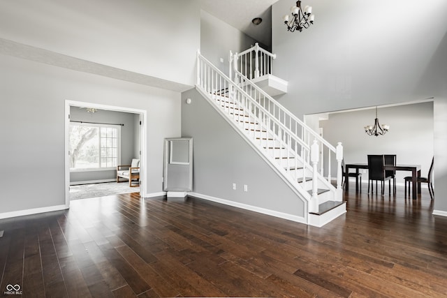 12861 Clifford Cir, Carmel, IN 46032 - unfurnished living room with a chandelier, stairway, a high ceiling, and wood finished floors