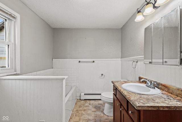 120 W N St, Tipton, IN 46072 - bathroom featuring a baseboard radiator, a wainscoted wall, a bath, vanity, and stone finish flooring