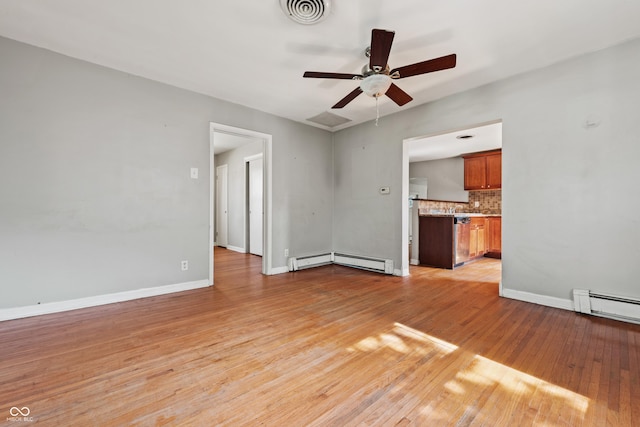 120 W N St, Tipton, IN 46072 - unfurnished living room featuring ceiling fan, light wood finished floors, and a baseboard heating unit