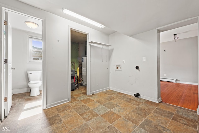120 W N St, Tipton, IN 46072 - laundry area with baseboard heating, stone tile flooring, washer hookup, and water heater