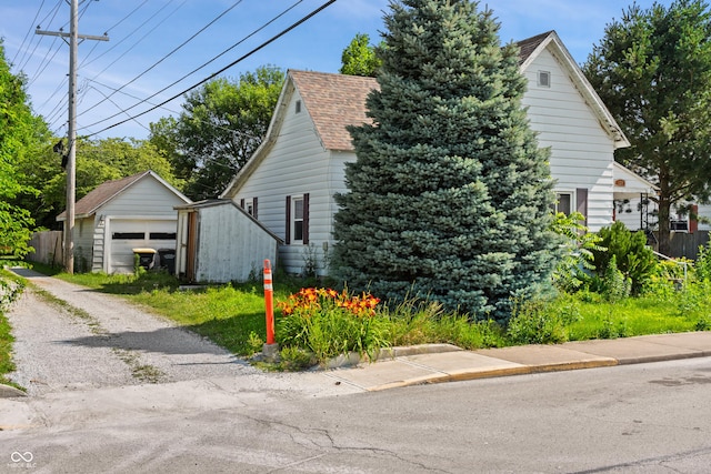 120 W N St, Tipton, IN 46072 - view of property exterior with an outdoor structure, driveway, a garage, and roof with shingles
