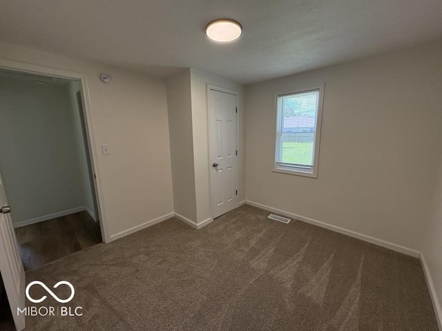 5725 N Clover Maple Dr, Fairland, IN 46126 - unfurnished bedroom with dark colored carpet and baseboards