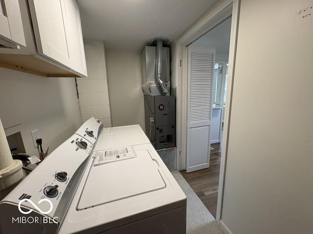 5725 N Clover Maple Dr, Fairland, IN 46126 - laundry area featuring separate washer and dryer, cabinet space, wood finished floors, and heating unit