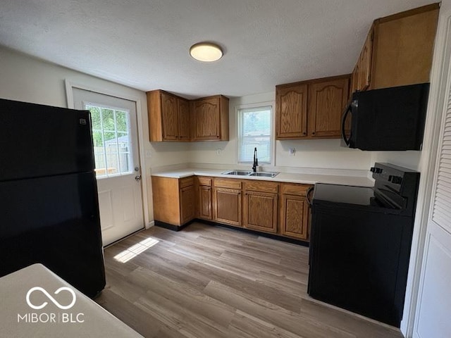 5725 N Clover Maple Dr, Fairland, IN 46126 - kitchen featuring black appliances, brown cabinets, light wood finished floors, light countertops, and a textured ceiling