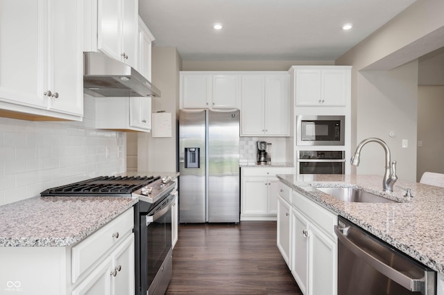 12888 Girvan Way, Fishers, IN 46037 - kitchen with stainless steel appliances, under cabinet range hood, decorative backsplash, white cabinetry, and light stone counters