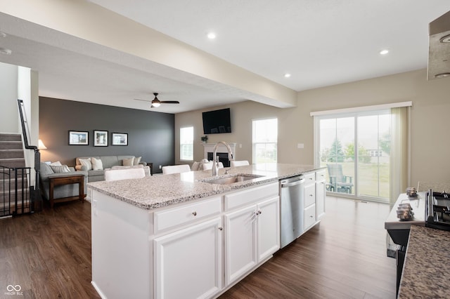 12888 Girvan Way, Fishers, IN 46037 - kitchen featuring dishwasher, dark wood-style flooring, a fireplace, a center island with sink, and light stone countertops