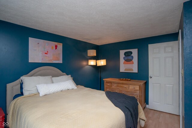6118 Thrushwood Cir, Indianapolis, IN 46250 - bedroom featuring wood finished floors and a textured ceiling