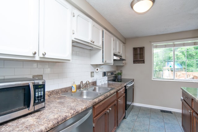 6118 Thrushwood Cir, Indianapolis, IN 46250 - kitchen featuring stainless steel appliances, under cabinet range hood, decorative backsplash, white cabinetry, and light tile patterned floors