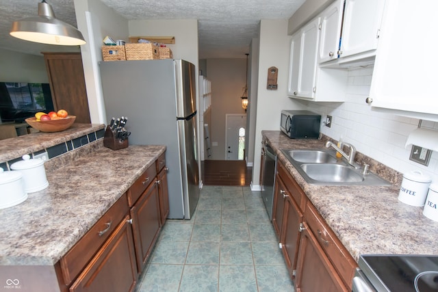 6118 Thrushwood Cir, Indianapolis, IN 46250 - kitchen featuring appliances with stainless steel finishes, tasteful backsplash, white cabinets, tile patterned flooring, and a textured ceiling