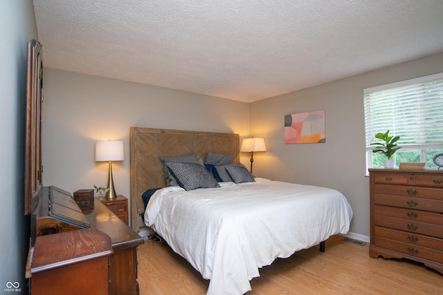6118 Thrushwood Cir, Indianapolis, IN 46250 - bedroom with light wood-type flooring and a textured ceiling