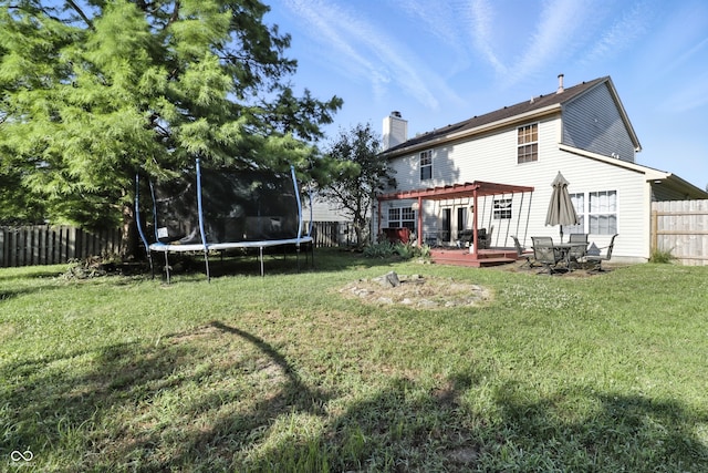 8321 Giroud Way, Indianapolis, IN 46259 - rear view of house featuring a trampoline, a deck, a fenced backyard, a chimney, and a pergola