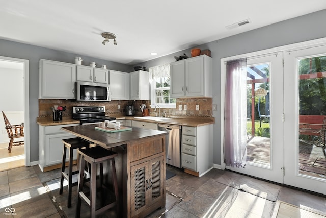 8321 Giroud Way, Indianapolis, IN 46259 - kitchen featuring appliances with stainless steel finishes, decorative backsplash, white cabinets, a breakfast bar, and recessed lighting