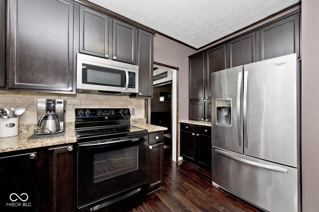 1093 Springwater Dr, Greenwood, IN 46143 - kitchen featuring stainless steel appliances, dark wood-type flooring, backsplash, dark brown cabinets, and light stone countertops