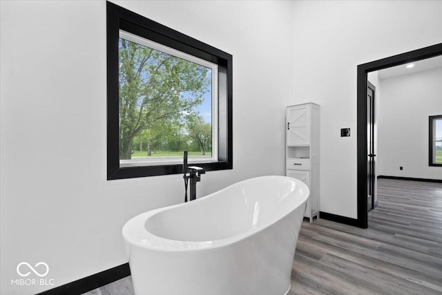 8237 S 100 E, Markleville, IN 46056 - bathroom featuring healthy amount of natural light, a freestanding bath, and wood finished floors
