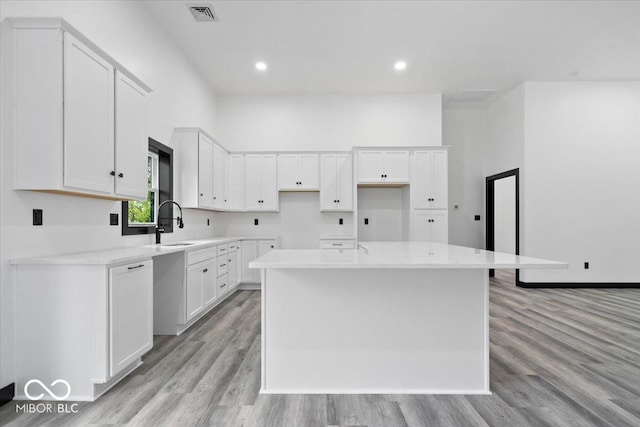 8237 S 100 E, Markleville, IN 46056 - kitchen with a center island, light wood finished floors, white cabinetry, recessed lighting, and light countertops
