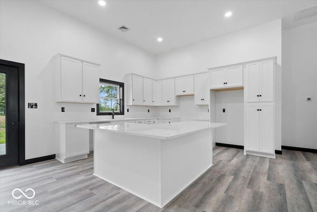 8237 S 100 E, Markleville, IN 46056 - kitchen with a center island, white cabinetry, light wood-type flooring, recessed lighting, and a towering ceiling