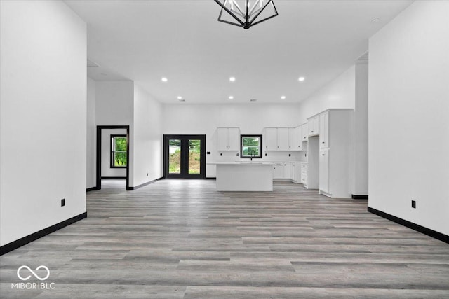 8237 S 100 E, Markleville, IN 46056 - unfurnished living room featuring recessed lighting, light wood finished floors, a high ceiling, and french doors