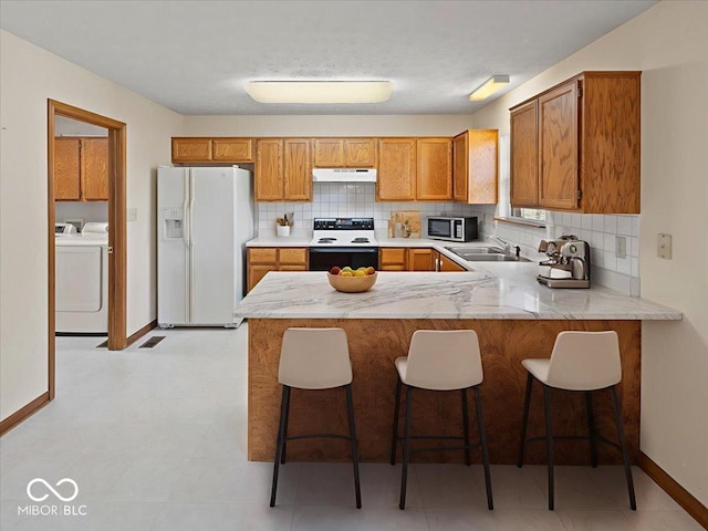 294 Keller Dr, Greenfield, IN 46140 - kitchen featuring white fridge with ice dispenser, electric range oven, under cabinet range hood, washing machine and dryer, and stainless steel microwave