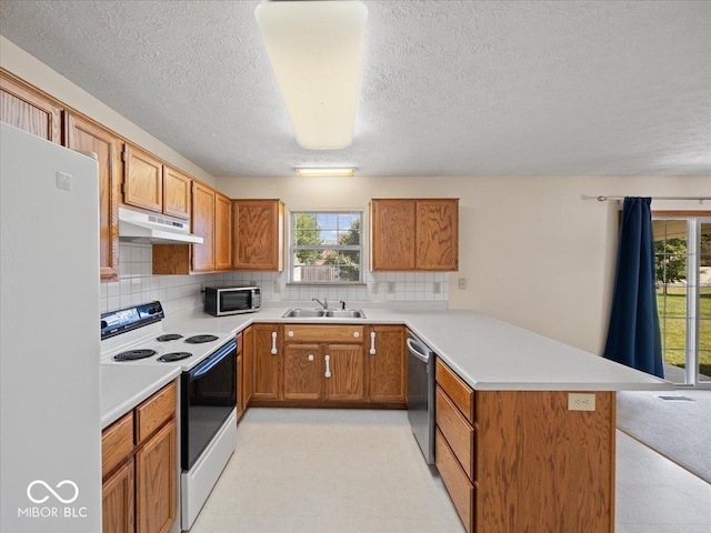 294 Keller Dr, Greenfield, IN 46140 - kitchen featuring appliances with stainless steel finishes, a peninsula, under cabinet range hood, light flooring, and plenty of natural light