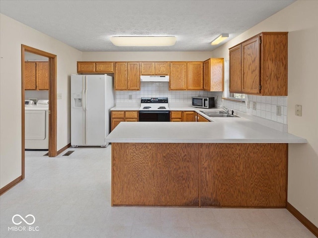 294 Keller Dr, Greenfield, IN 46140 - kitchen with white appliances, extractor fan, washing machine and dryer, light countertops, and brown cabinetry