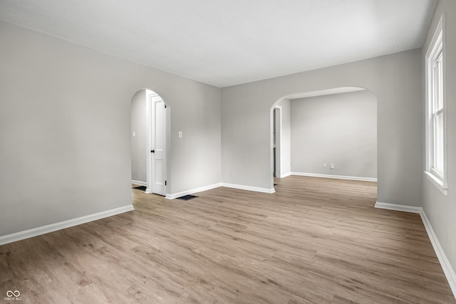 726 N Routiers Ave, Indianapolis, IN 46219 - empty room featuring arched walkways and wood finished floors