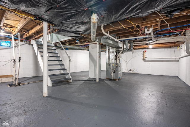 726 N Routiers Ave, Indianapolis, IN 46219 - unfinished below grade area featuring stairs, heating unit, and concrete block wall