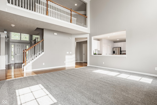 11761 Boothbay Ln, Fishers, IN 46037 - unfurnished living room with carpet flooring, a high ceiling, stairway, and recessed lighting