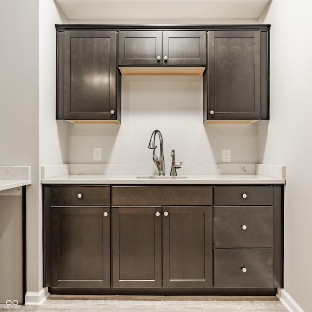 11761 Boothbay Ln, Fishers, IN 46037 - kitchen featuring dark brown cabinetry, light countertops, and light wood-style flooring