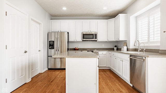 11761 Boothbay Ln, Fishers, IN 46037 - kitchen with appliances with stainless steel finishes, a center island, white cabinetry, light wood-style floors, and recessed lighting