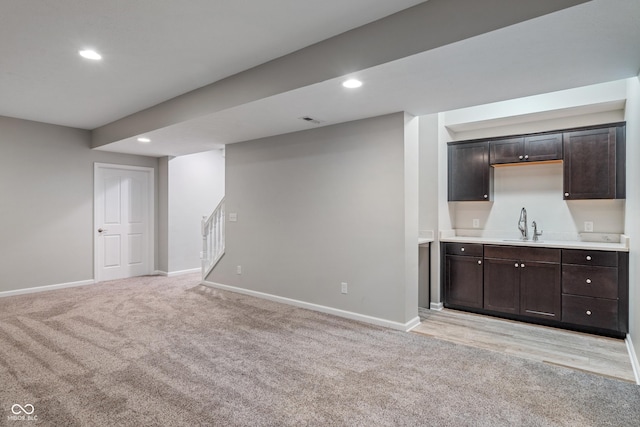 11761 Boothbay Ln, Fishers, IN 46037 - unfurnished living room with light colored carpet, wet bar, stairs, and recessed lighting