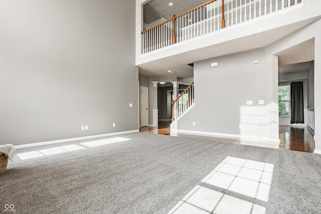 11761 Boothbay Ln, Fishers, IN 46037 - unfurnished living room featuring decorative columns, carpet, a towering ceiling, stairs, and recessed lighting