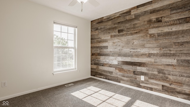 11761 Boothbay Ln, Fishers, IN 46037 - carpeted empty room featuring wood walls and ceiling fan