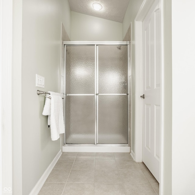 11761 Boothbay Ln, Fishers, IN 46037 - bathroom featuring tile patterned flooring, a stall shower, and a textured ceiling