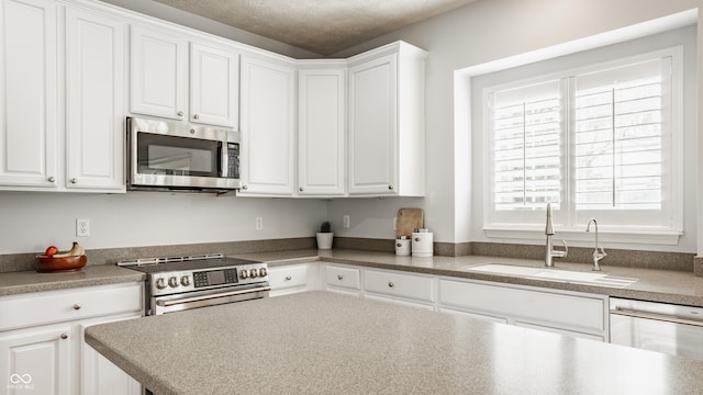 11761 Boothbay Ln, Fishers, IN 46037 - kitchen featuring stainless steel appliances, white cabinets, and a textured ceiling