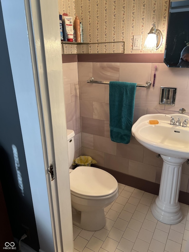 519 E Wabash Ave, Crawfordsville, IN 47933 - half bathroom with tile walls, tile patterned flooring, ornate columns, and a wainscoted wall