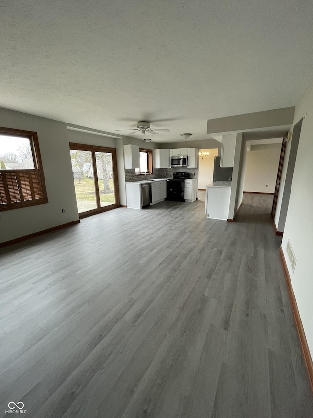 2068 Suda Dr, Carmel, IN 46280 - unfurnished living room featuring dark wood-style flooring and ceiling fan