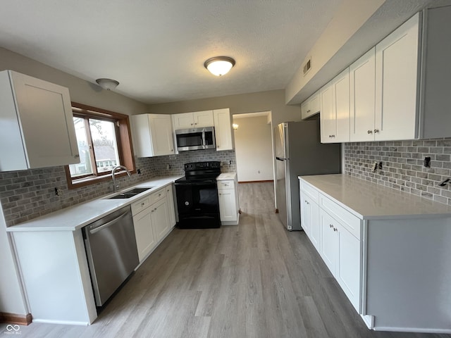 2068 Suda Dr, Carmel, IN 46280 - kitchen featuring stainless steel appliances, light wood finished floors, white cabinetry, and backsplash